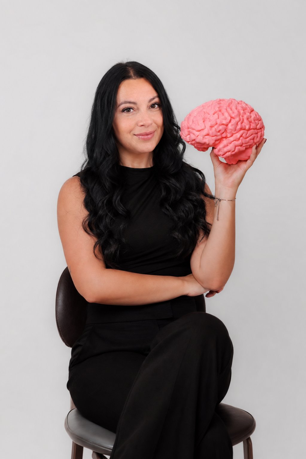 melinda, founder of mindful wellness clinic, holding a model brain