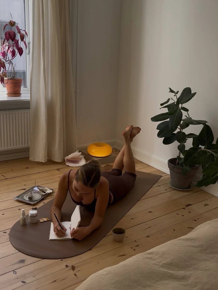 journalling on a mat in a calm, sunlit room
